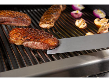 Grilled meat and vegetables on a barbecue with tongs
