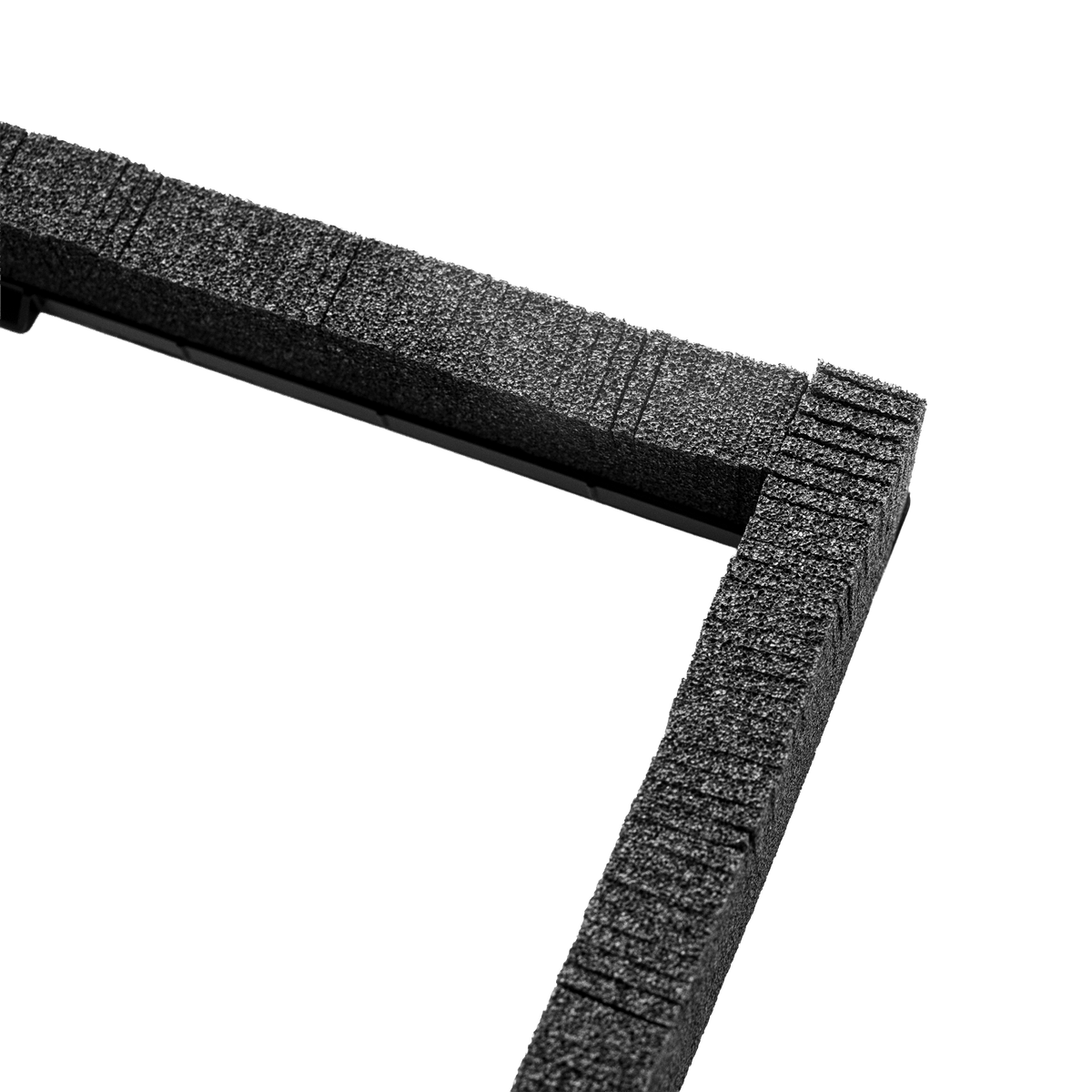 Close-up of a black textured foam frame corner on a solid white background.
